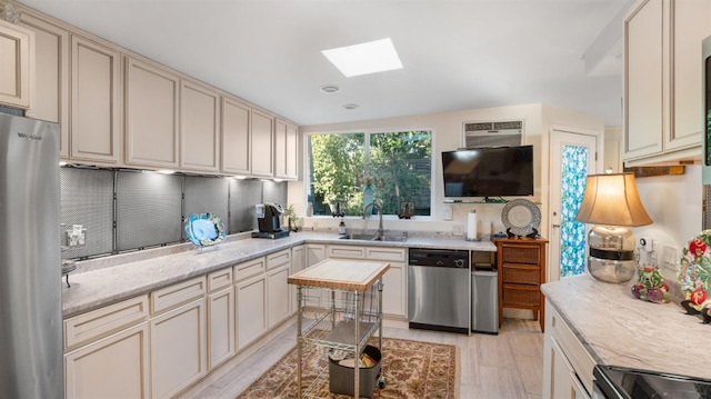 1403 Rowena Way, Sacramento, CA 95864 - kitchen featuring stainless steel appliances, a skylight, a sink, cream cabinets, and light stone counters