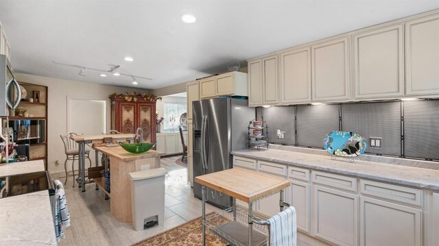 1403 Rowena Way, Sacramento, CA 95864 - kitchen with appliances with stainless steel finishes, light wood-style floors, cream cabinetry, and light stone counters
