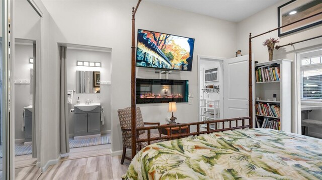1403 Rowena Way, Sacramento, CA 95864 - bedroom featuring wood finished floors, a sink, a glass covered fireplace, baseboards, and ensuite bath