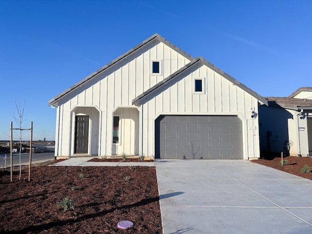 view of front facade with a garage, driveway, and board and batten siding