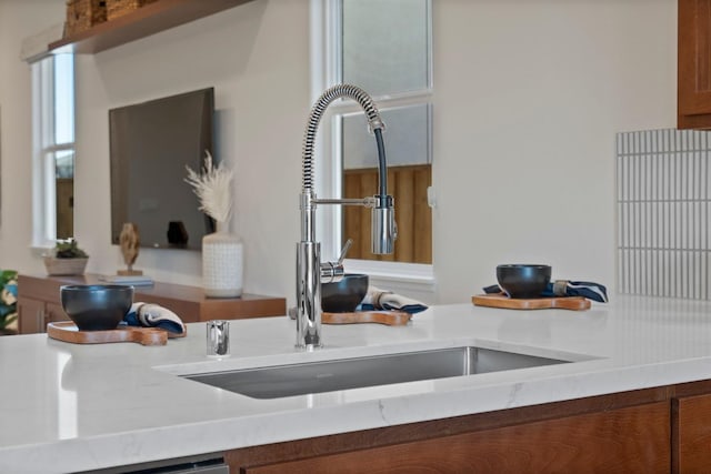 room details featuring brown cabinetry, light countertops, and a sink