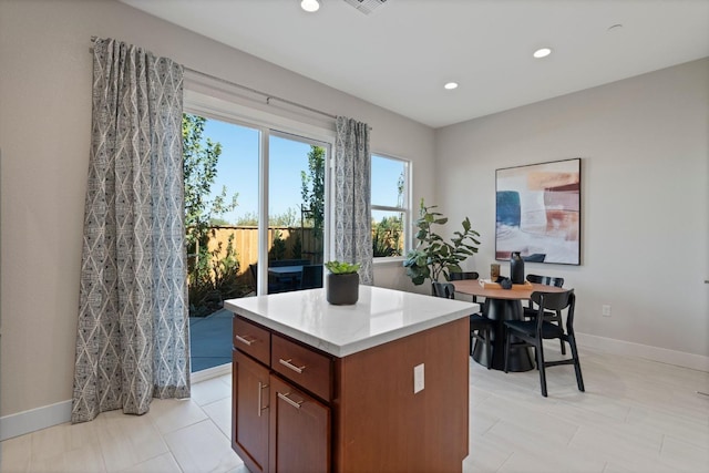 kitchen featuring recessed lighting, a kitchen island, visible vents, baseboards, and light countertops