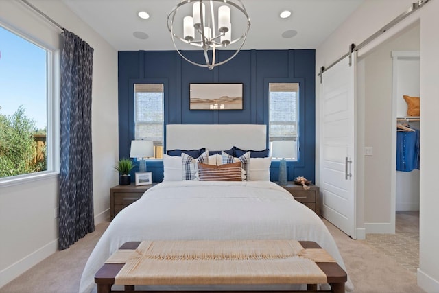 bedroom featuring a barn door, multiple windows, a chandelier, and light colored carpet