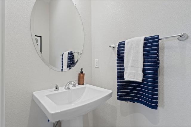 bathroom with a sink and a textured wall