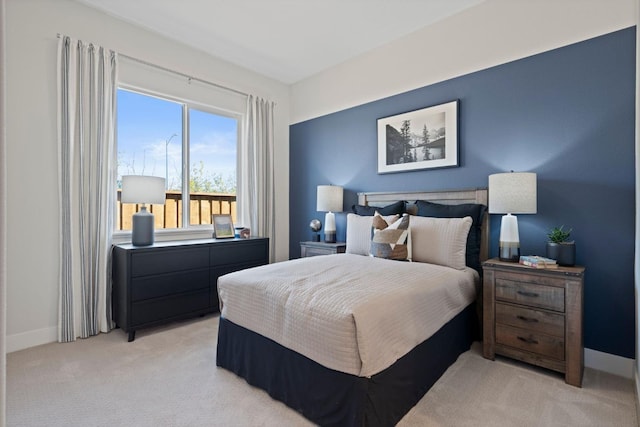 bedroom with light carpet and baseboards