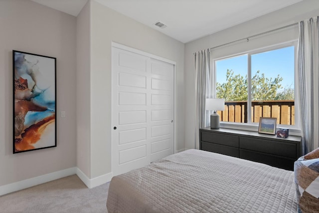 bedroom featuring baseboards, visible vents, a closet, and light colored carpet