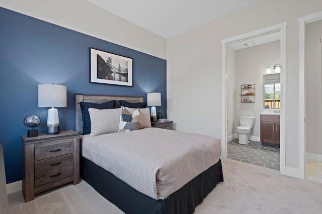 bedroom with baseboards, visible vents, carpet flooring, and ensuite bathroom