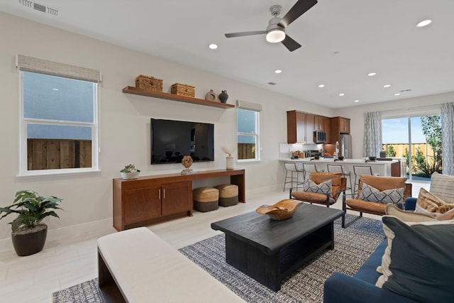 living room featuring baseboards, ceiling fan, visible vents, and recessed lighting