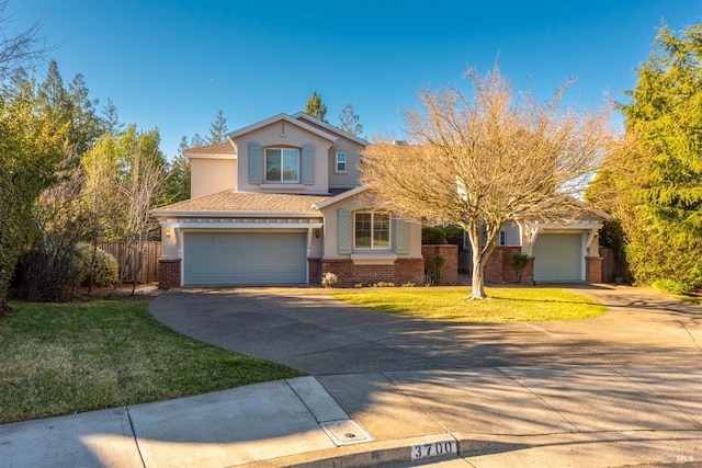 traditional-style home with a front lawn, brick siding, driveway, and stucco siding