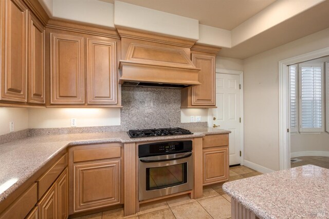 kitchen with stainless steel oven, black gas cooktop, light countertops, and light tile patterned floors