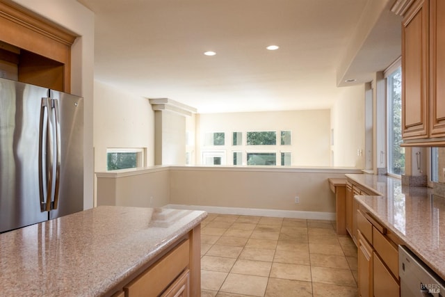 kitchen with baseboards, plenty of natural light, and freestanding refrigerator
