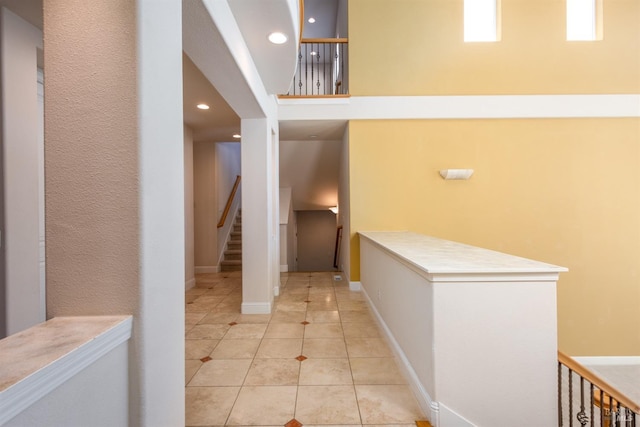 hall featuring light tile patterned floors, recessed lighting, and baseboards