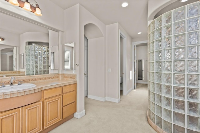 bathroom with vanity, recessed lighting, baseboards, and walk in shower