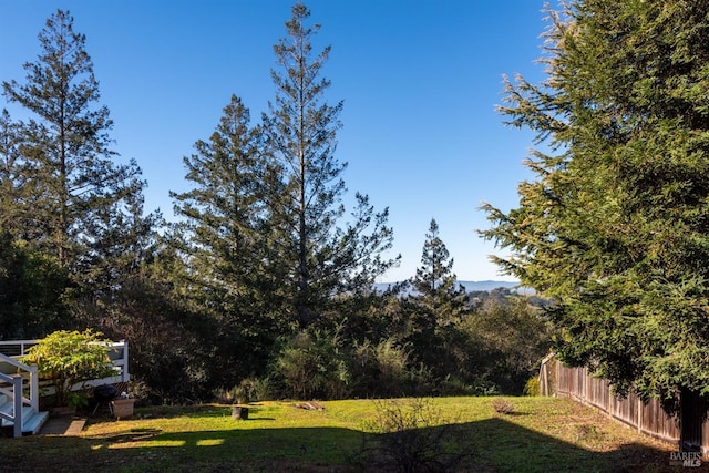 view of yard with fence and a forest view