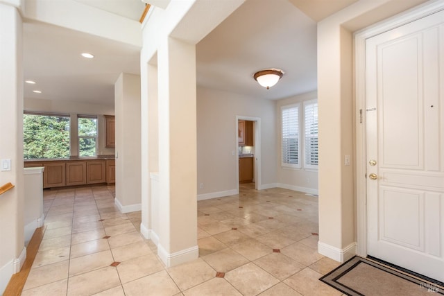 hallway featuring light tile patterned floors, baseboards, and recessed lighting