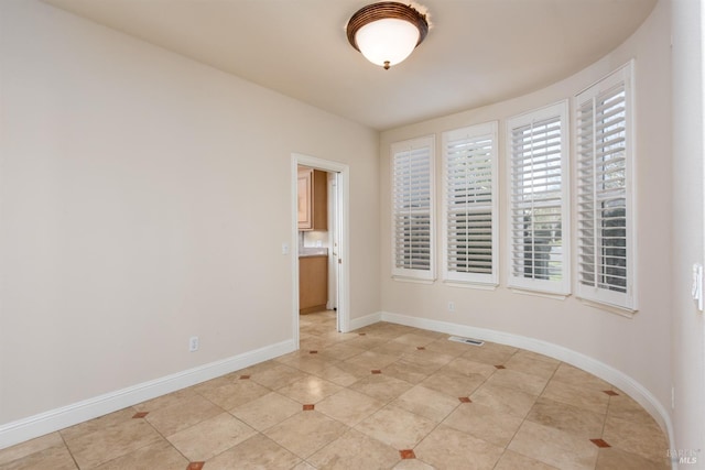 unfurnished room featuring light tile patterned floors, visible vents, and baseboards