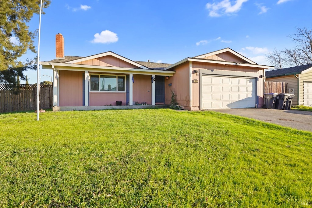 ranch-style home featuring a garage and a front lawn