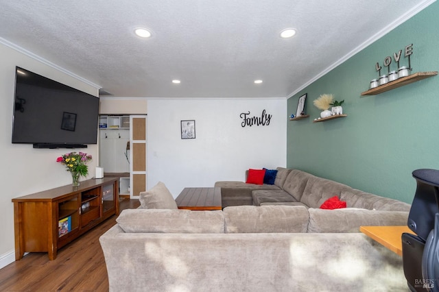 living room with a textured ceiling, hardwood / wood-style flooring, and crown molding