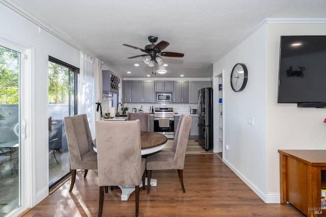 dining space with ceiling fan, dark wood-type flooring, and crown molding