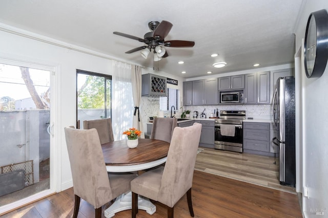 dining space with ceiling fan, crown molding, sink, and wood-type flooring