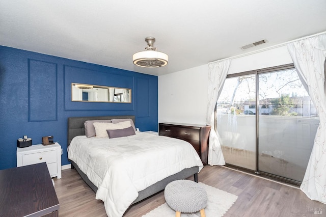 bedroom with ceiling fan, access to outside, and hardwood / wood-style floors