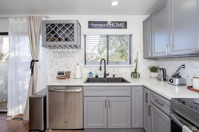 kitchen featuring sink, range with electric cooktop, stainless steel dishwasher, gray cabinets, and dark wood-type flooring