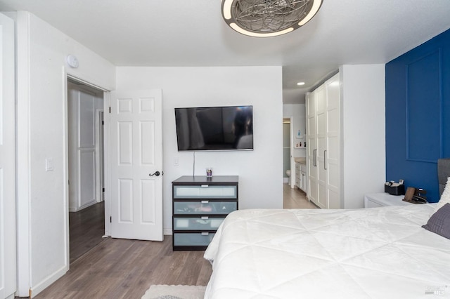 bedroom with ensuite bathroom and wood-type flooring