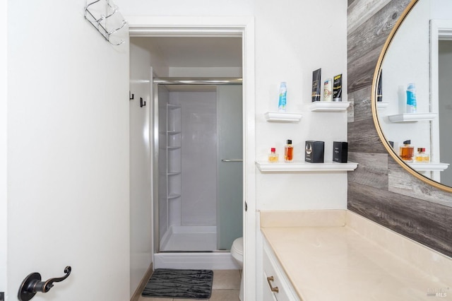 bathroom featuring vanity, toilet, walk in shower, and tile patterned floors