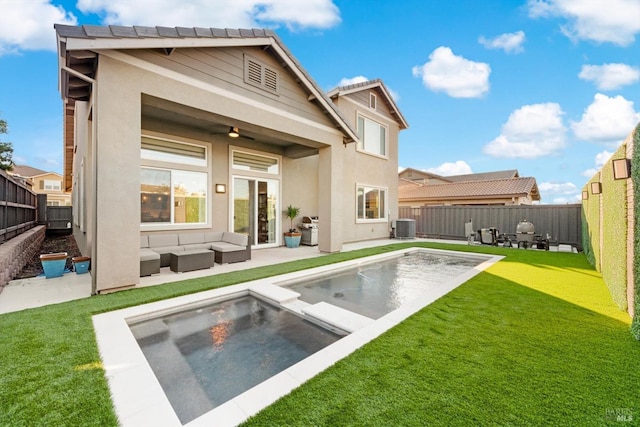 rear view of property with a fenced in pool, a patio area, outdoor lounge area, and a yard