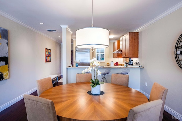 dining room featuring ornamental molding and dark hardwood / wood-style flooring