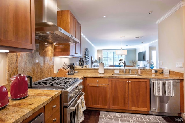 kitchen with stainless steel appliances, wall chimney range hood, light stone countertops, ornamental molding, and sink