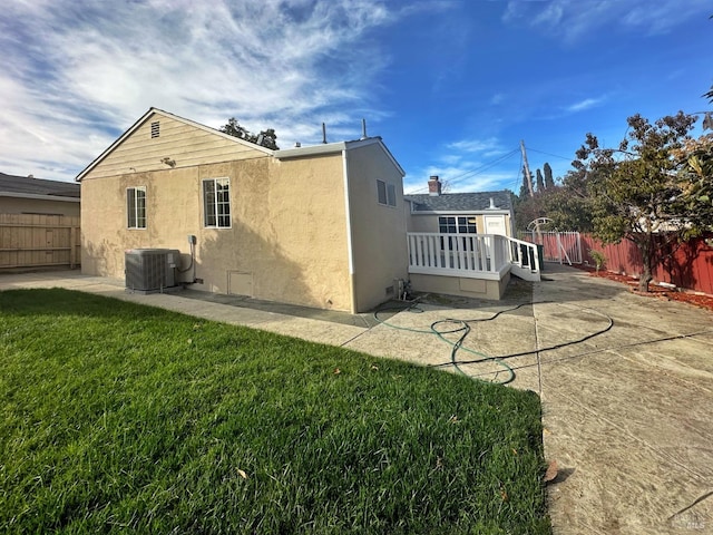 back of property with a patio area, cooling unit, and a yard