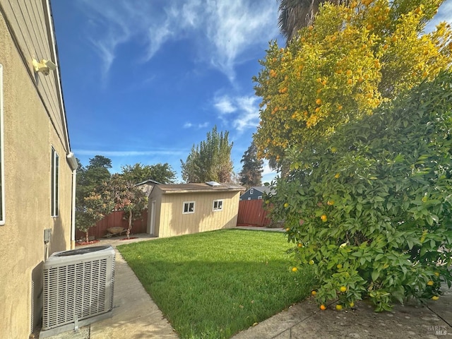 view of yard featuring a shed and central AC