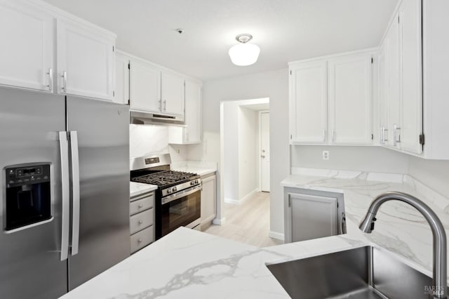 kitchen featuring sink, white cabinets, light stone countertops, and appliances with stainless steel finishes