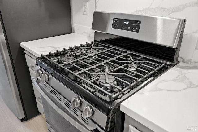 details with light stone countertops and gas stove