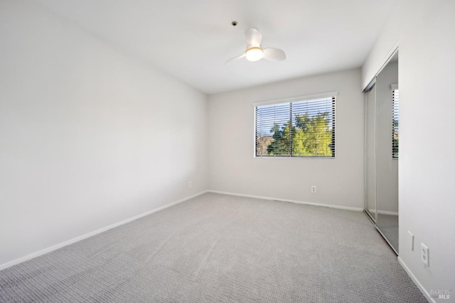 carpeted spare room with ceiling fan