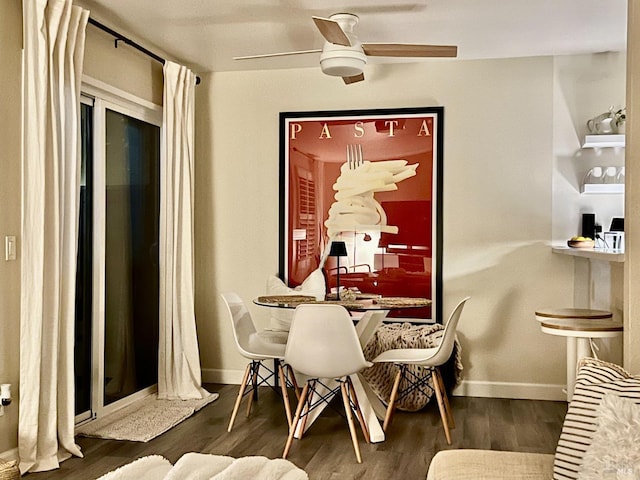 dining area with dark wood-type flooring and ceiling fan