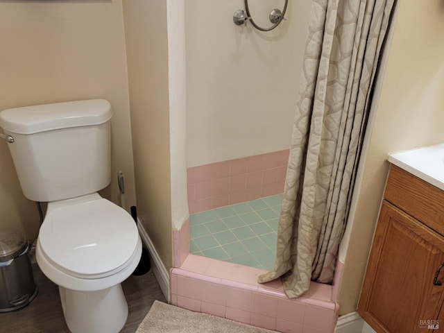 bathroom featuring toilet, curtained shower, and vanity