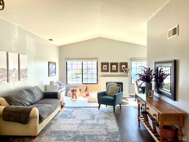 living room with lofted ceiling, a fireplace, and hardwood / wood-style flooring