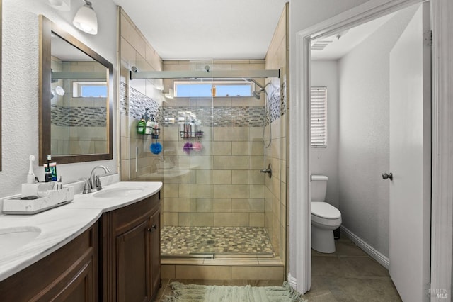 bathroom featuring vanity, tile patterned floors, toilet, and walk in shower