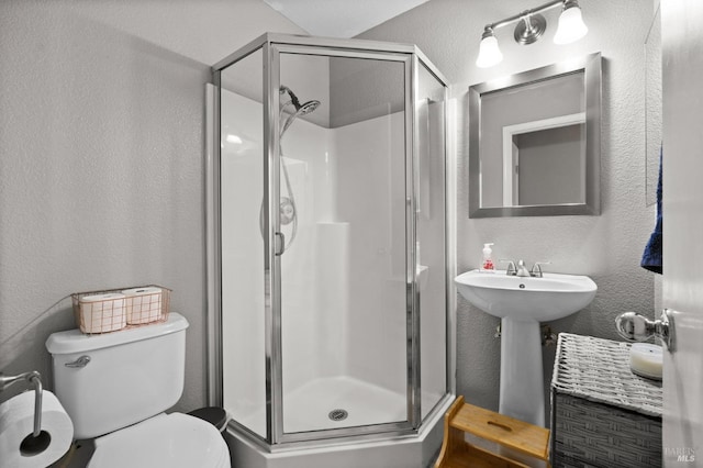 bathroom featuring an enclosed shower, sink, and toilet