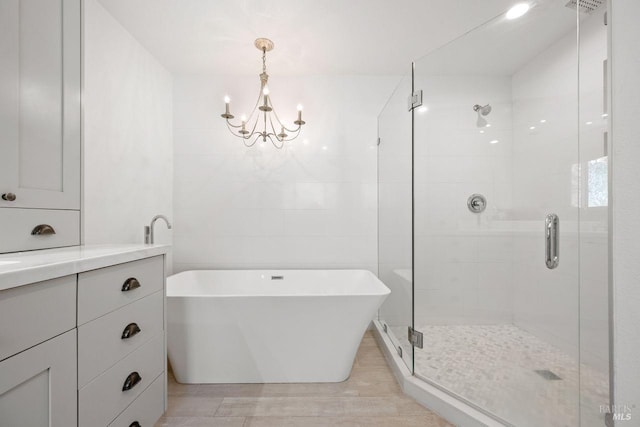 bathroom featuring vanity, an inviting chandelier, and independent shower and bath