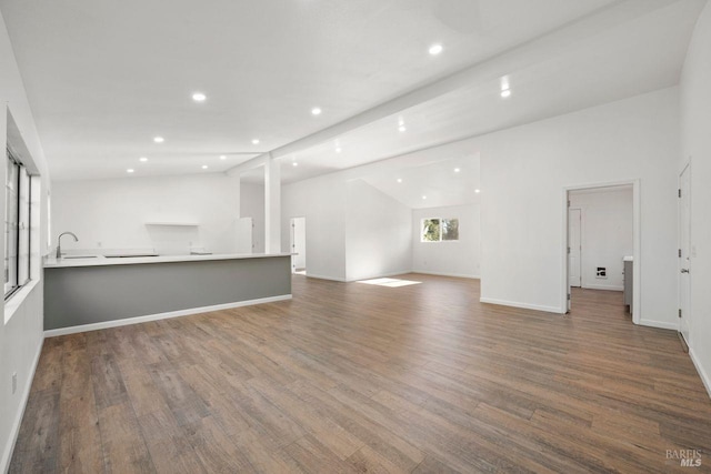 unfurnished living room featuring vaulted ceiling and dark hardwood / wood-style floors