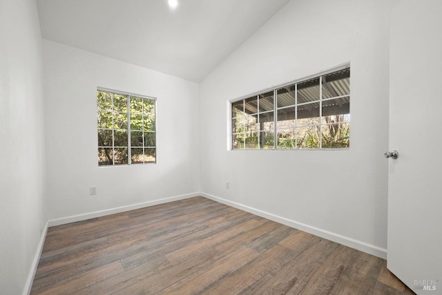 unfurnished room featuring dark wood-type flooring and vaulted ceiling