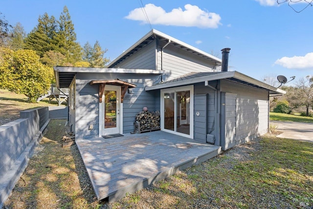 rear view of house with a deck and a lawn