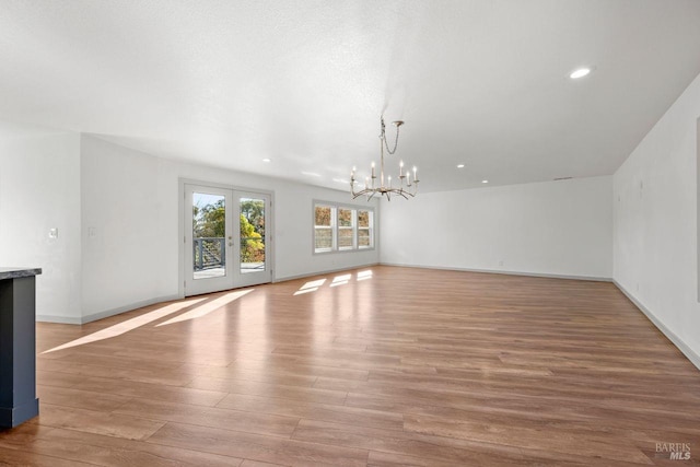 interior space featuring french doors, an inviting chandelier, and light wood-type flooring