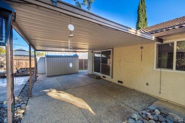 view of patio / terrace with a storage shed, fence, and an outdoor structure