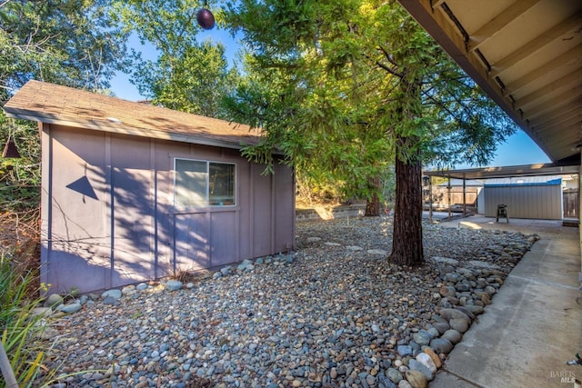 view of yard with an outbuilding, a storage unit, and a hot tub