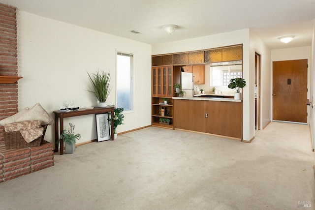 kitchen with white fridge and light carpet