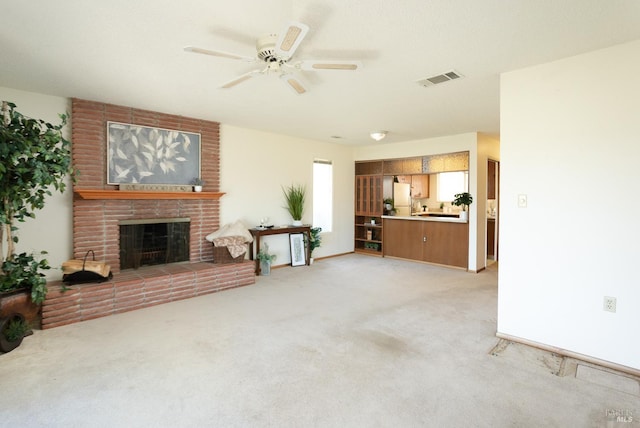 carpeted living room featuring a brick fireplace and ceiling fan